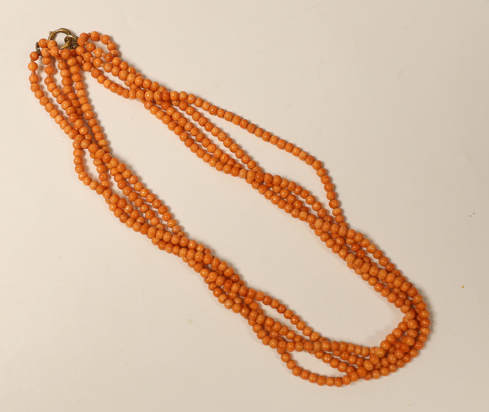 A quadruple strand coral bead necklace, with a gold plated clasp, 46cm.